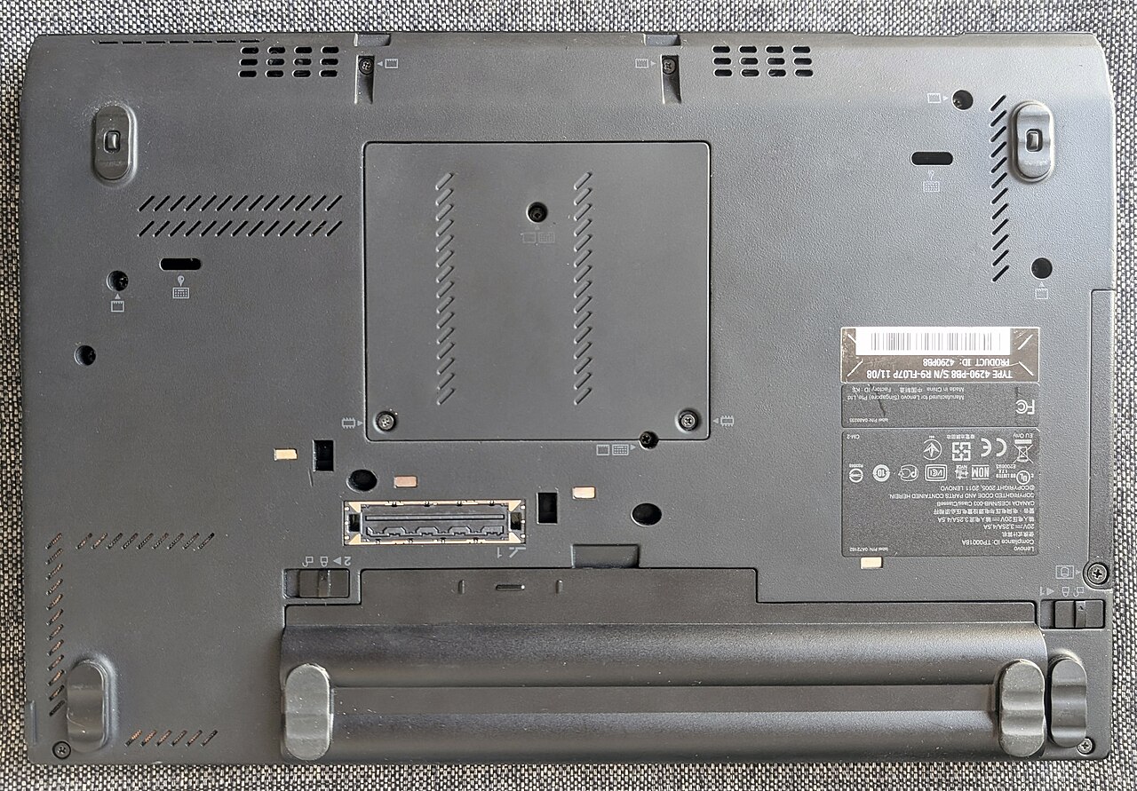 Mặt đáy laptop với tem thông số kỹ thuật và số serial